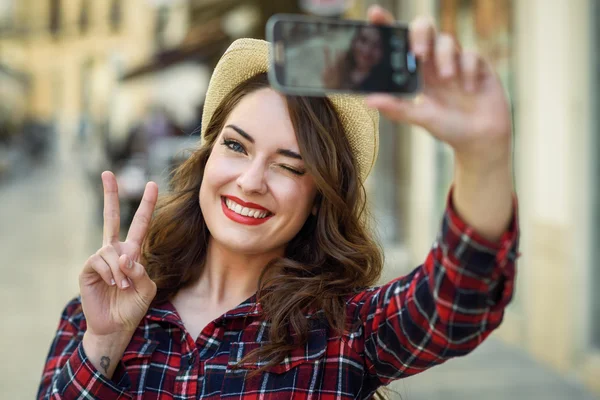 年轻女子自拍照在街上与一部智能手机 — 图库照片