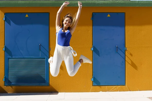 Glückliche junge Frau springt im urbanen Hintergrund — Stockfoto