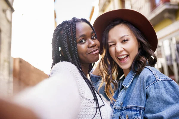 Twee mooie multi-etnische vrouwen maken selfie en grimmige — Stockfoto