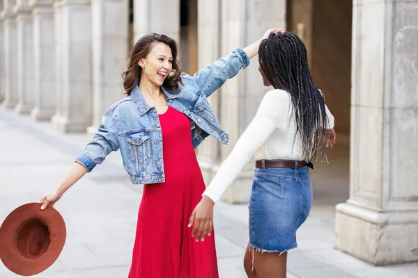 Dois amigos felizes em ver-se na rua abraçando. — Fotografia de Stock