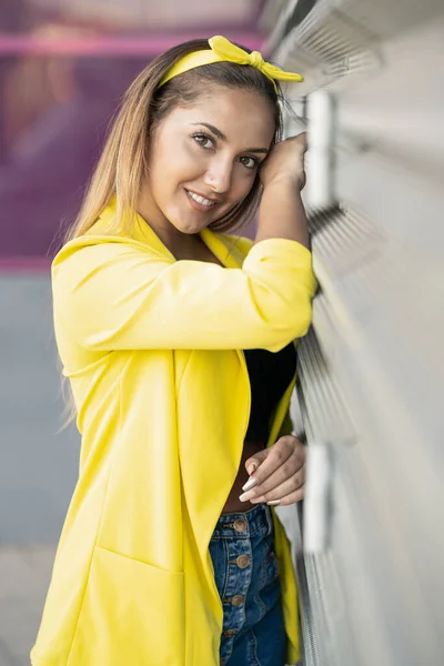 Jovem mulher vestindo uma jaqueta amarela e headband — Fotografia de Stock