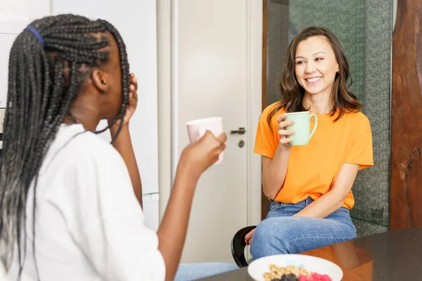 Twee vrienden die een gezonde snack eten terwijl ze thuis chatten — Stockfoto