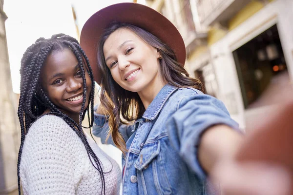 Duas belas mulheres multiétnicas fazendo selfie e sorridente — Fotografia de Stock