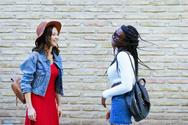 Zwei Freundinnen amüsieren sich gemeinsam auf der Straße. Multiethnische Freunde. — Stockfoto