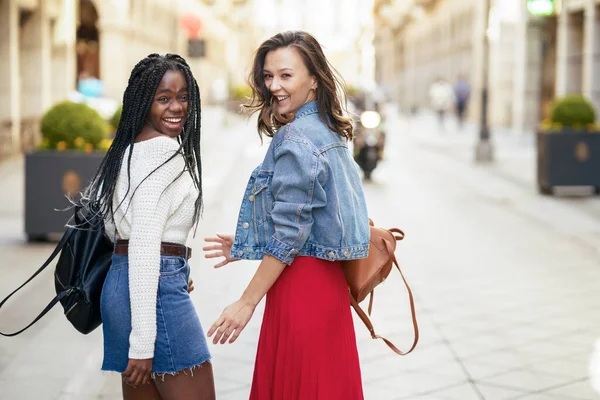 Dos amigas divirtiéndose juntas en la calle. Amigos multiétnicos. — Foto de Stock