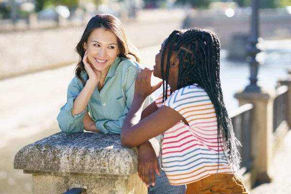 Två multietniska kvinnor som talar tillsammans på gatan. — Stockfoto