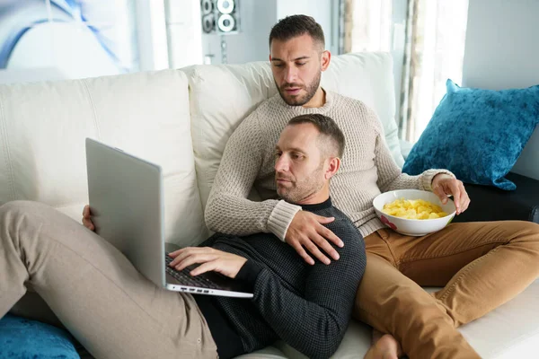 Pareja gay consultando sus planes de viaje junto con un portátil. —  Fotos de Stock