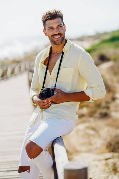 Uśmiechnięty mężczyzna fotografujący w strefie przybrzeżnej. — Zdjęcie stockowe