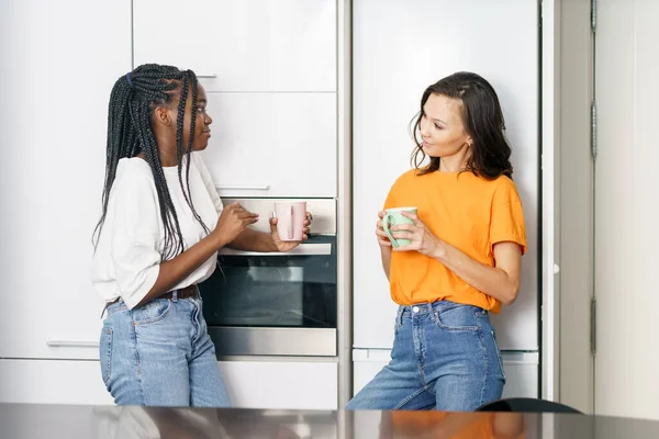 Twee studenten vrienden nemen een koffiepauze samen thuis. — Stockfoto