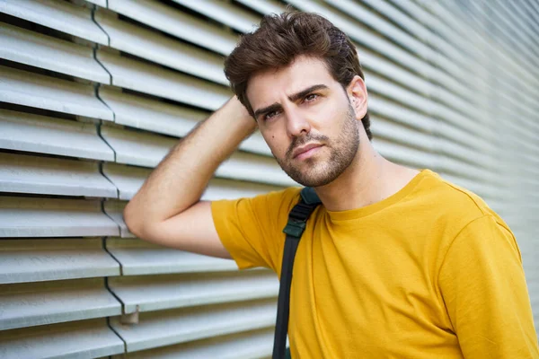 Jovem com corte de cabelo moderno em fundo urbano — Fotografia de Stock