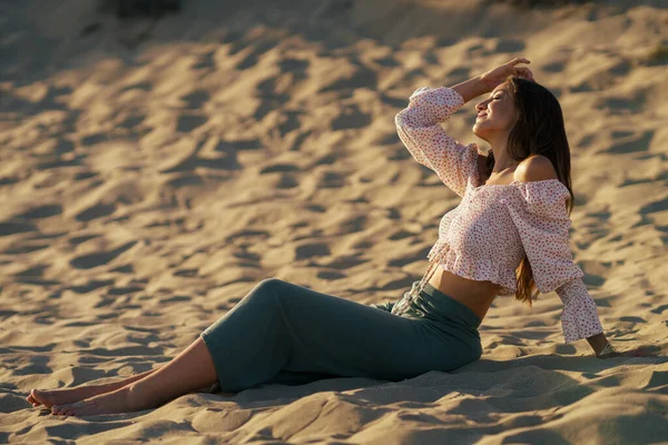 Ελκυστική γυναίκα κάθεται στην άμμο της παραλίας — Φωτογραφία Αρχείου