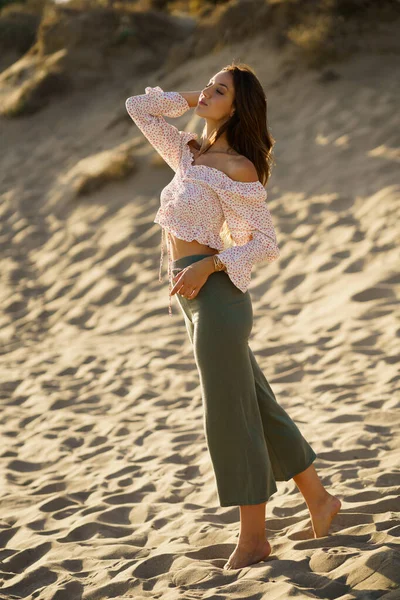 Jovem mulher bonita de pé na areia da praia — Fotografia de Stock