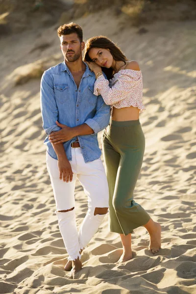 Young couple standing on the sand of the beach — Stock Photo, Image