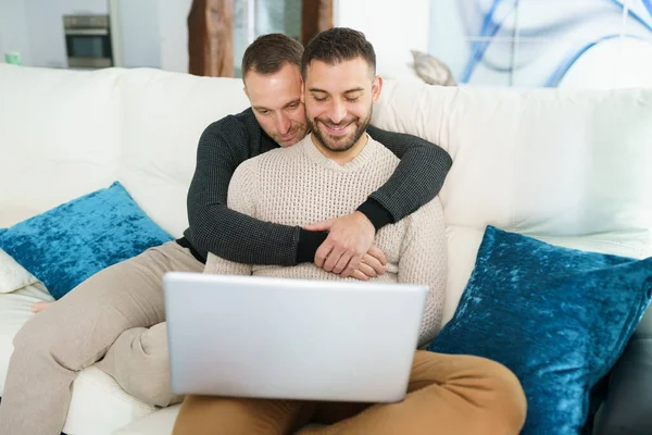 Couple gay consulter leurs plans de voyage avec un ordinateur portable. — Photo