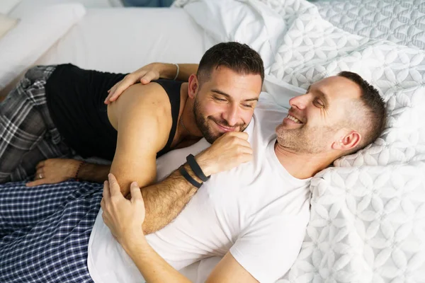 Gay couple câlin ensemble sur leur lit. — Photo