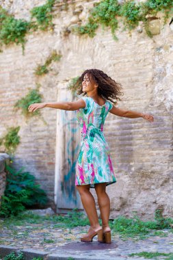 Güzel esmer, orta yaşlı bir kadın kollarını açmış kendine saldırıyor.