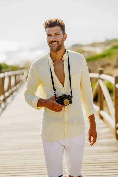 Uśmiechnięty mężczyzna fotografujący w strefie przybrzeżnej. — Zdjęcie stockowe