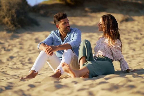 Attraktives Paar sitzt am Sand des Strandes — Stockfoto