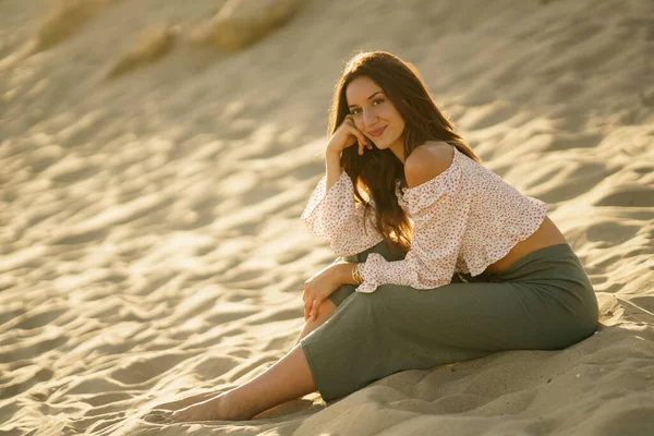 Mujer atractiva sentada en la arena de la playa — Foto de Stock
