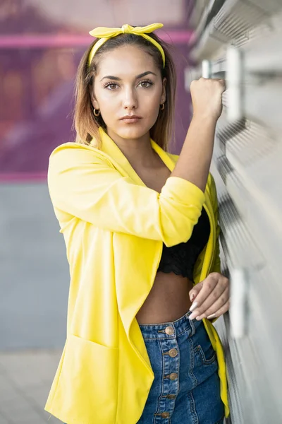 Mujer joven con una chaqueta amarilla y diadema — Foto de Stock