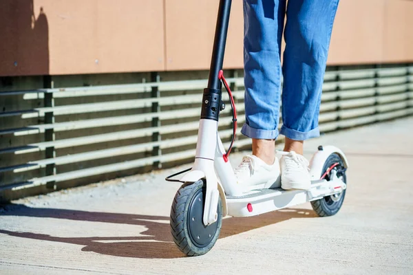 Mulher que circula na cidade com uma scooter elétrica — Fotografia de Stock