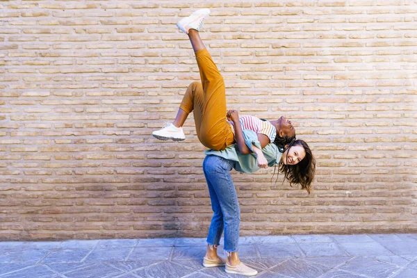 Rolig multietnisk kvinna bär sin bästa vän piggyback — Stockfoto