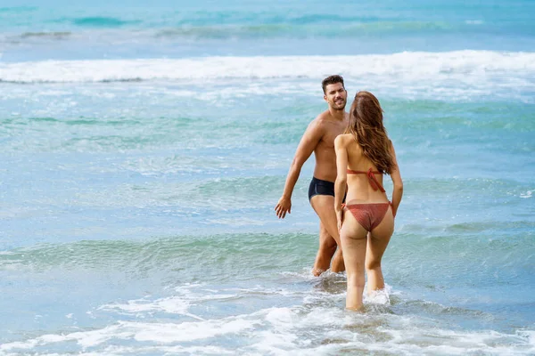 Jeune couple se baignant ensemble sur la plage profitant de leurs vacances en mer — Photo