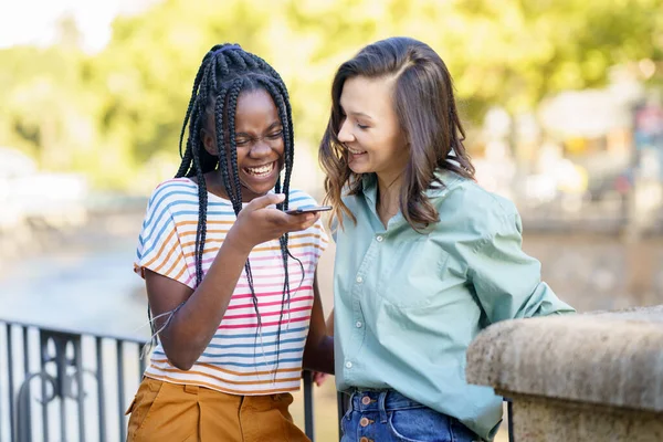 Zwei Freundinnen amüsieren sich gemeinsam auf der Straße. Multiethnische Freunde. — Stockfoto