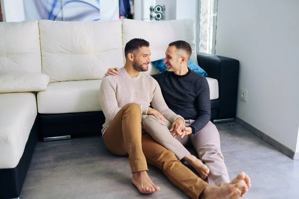 Bögpar sitter nära soffan hemma i ett romantiskt ögonblick — Stockfoto