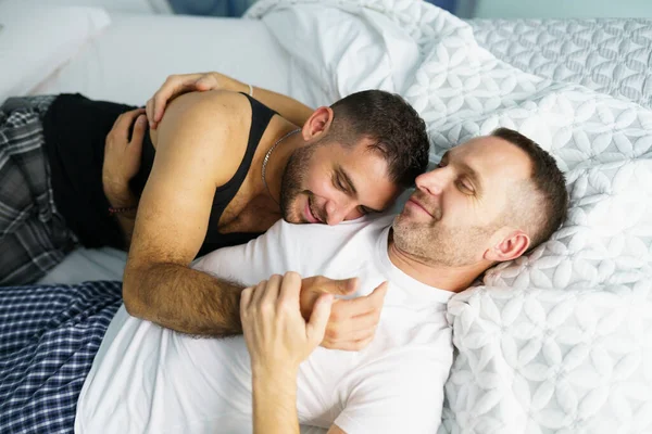 Gej para przytulanie razem na ich łóżko. — Zdjęcie stockowe
