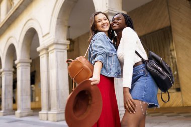 İki arkadaş birbirlerini sokakta sarılırken gördüklerine seviniyorlar..