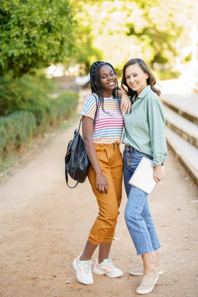 Dvě multietnické ženy pózující spolu s barevnými ležérní oblečení — Stock fotografie