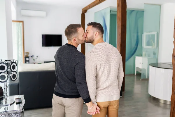 Gay couple kissing at their new home together. — Stockfoto