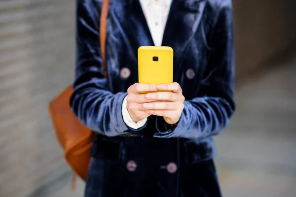 Donna d'affari che indossa un abito blu utilizzando lo smartphone in un edificio per uffici. — Foto Stock