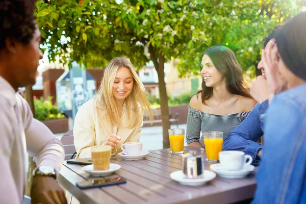Grupo multi-étnico de amigos tomando uma bebida juntos em um bar ao ar livre. — Fotografia de Stock