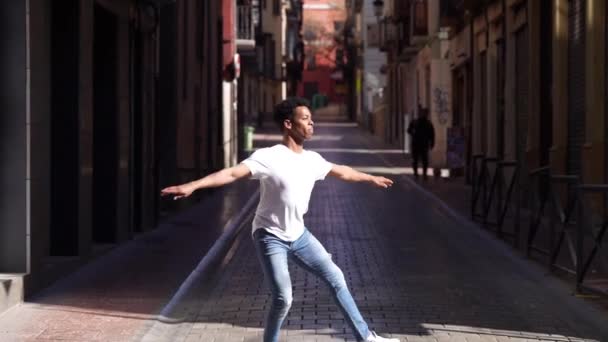 Młody czarny mężczyzna akrobata robi balet skok w ulicę. — Wideo stockowe