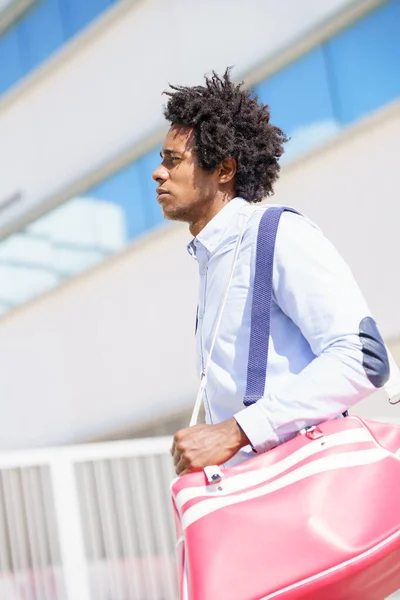 Black worker walking near an office building with a sports bag. — Stock Photo, Image