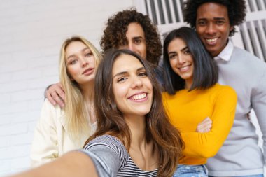 Çok ırklı bir grup arkadaş dışarıda eğlenirken selfie çekiyorlar..