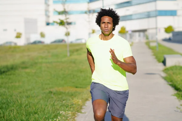 Чёрный атлетик бегает в городском парке. — стоковое фото