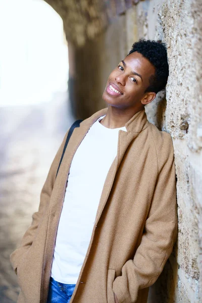 Młody czarny człowiek patrząc w aparat z szczęśliwy pełen nadziei spojrzenie na zewnątrz. — Zdjęcie stockowe