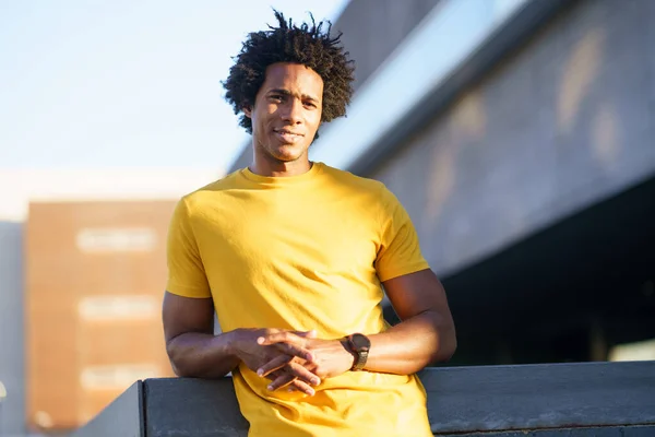 Black man with afro hair taking a break after workout.
