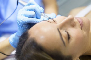 Güzellik salonunda güzel bir kadının kirpikleri için kalıcı makyaj. Mikro pigmentasyon tedavisi.