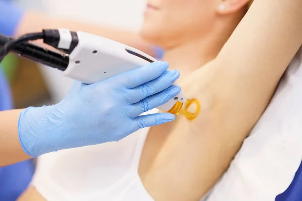 Woman receiving underarm laser hair removal at a beauty center. — Stock Photo, Image