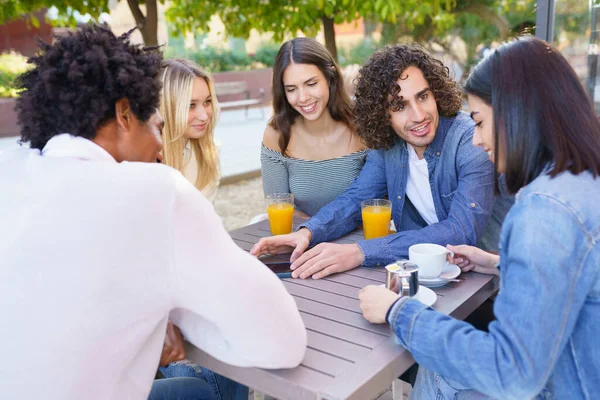 Grupo multiétnico de amigos tomando una copa juntos en un bar al aire libre. — Foto de Stock