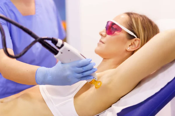 Woman receiving underarm laser hair removal at a beauty center. — Stock Photo, Image