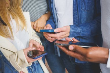 Akıllı telefon kullanan tanınmayan genç insanların elleri.