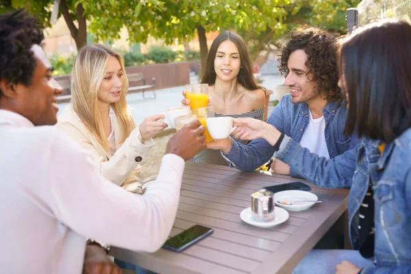 Grupo multiétnico de amigos brindando con sus bebidas mientras toman una copa juntos. — Foto de Stock