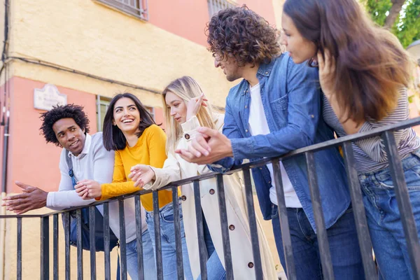 Grupo multiétnico de amigos se reunieron en la calle apoyados en una barandilla. — Foto de Stock