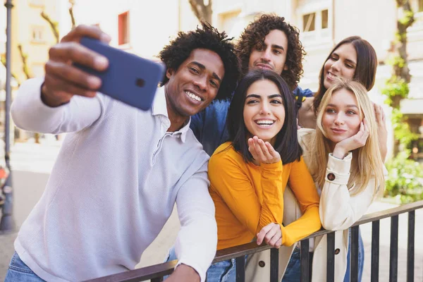 Black man with afro hair taking a smartphone selfie with his multi-ethnic group of friends. — Stock Photo, Image