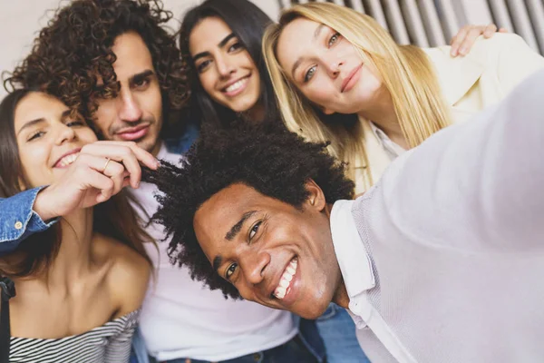 Multi-ethnic group of friends taking a selfie together while having fun outdoors. — Stock Photo, Image